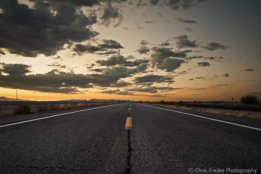 An open road with the AZ sun setting.