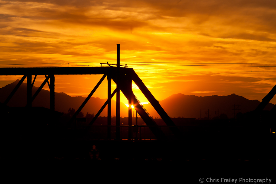 The Arizona sun sets on Tempe Town Lake train bridge.
