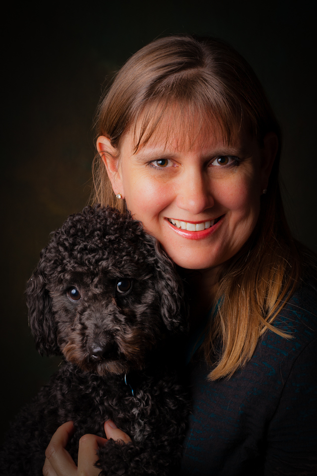 A female portrait holding a poodle.