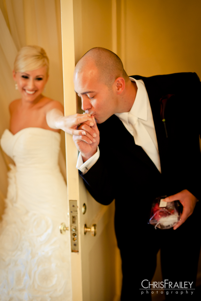Groom kissing bride's hand