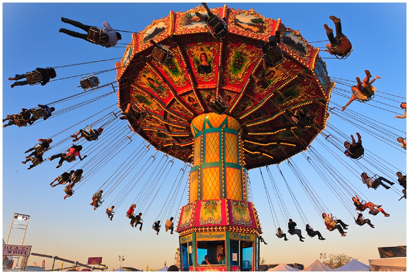 People enjoying a carnival swing ride as they fly through the air
