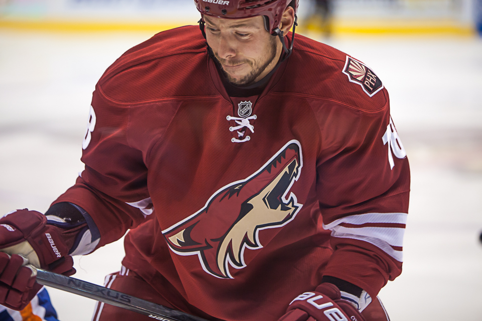 A Coyotes hockey player at the glass