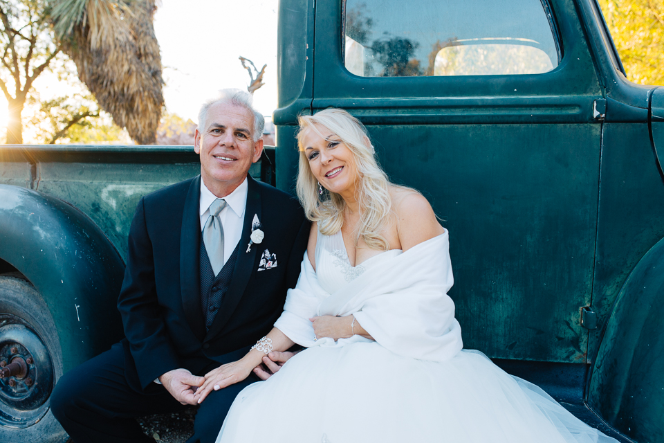 Bride and groom posing at the old truck for their Boojum Tree wedding
