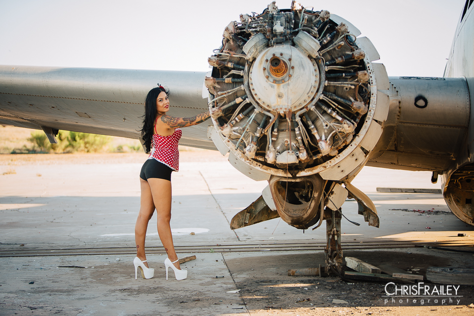 Pinup model posing near an aircraft engine