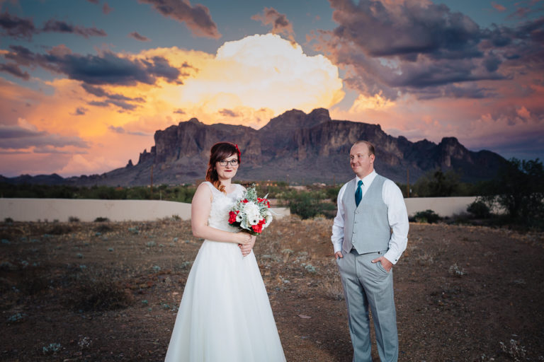Bride and groom pose in front of the Superstition Mountains