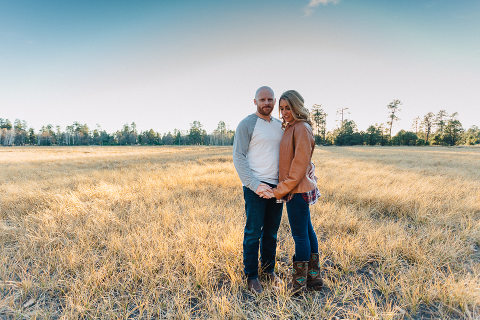Sunset photo of a couple standing in a field. 