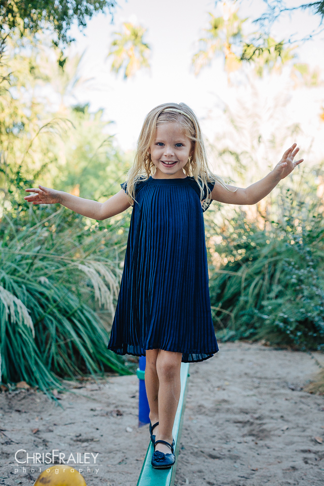 Small girl walking a balance beam for family pictures at the Phoenix Zoo.