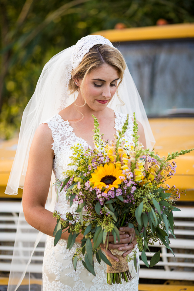 Bride posing in front of an old yellow truck.