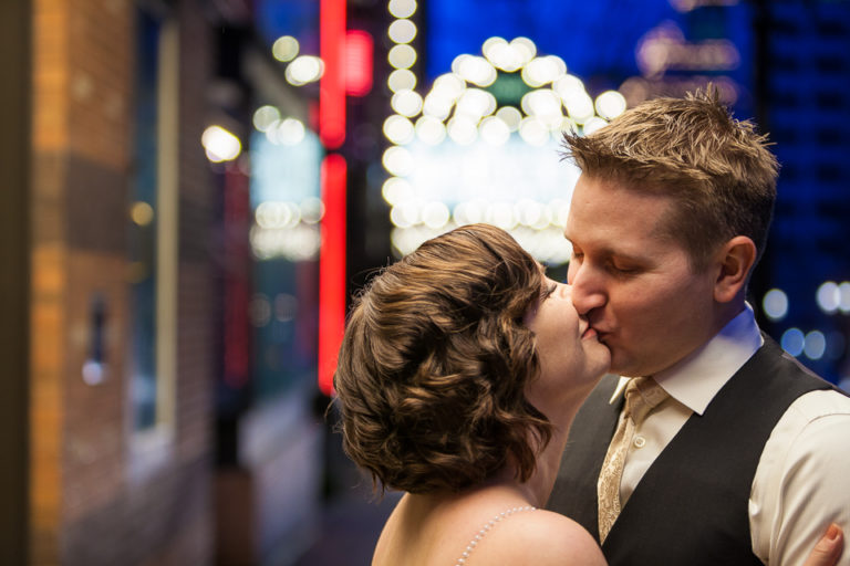 Bride and groom kissing by Portland Theater