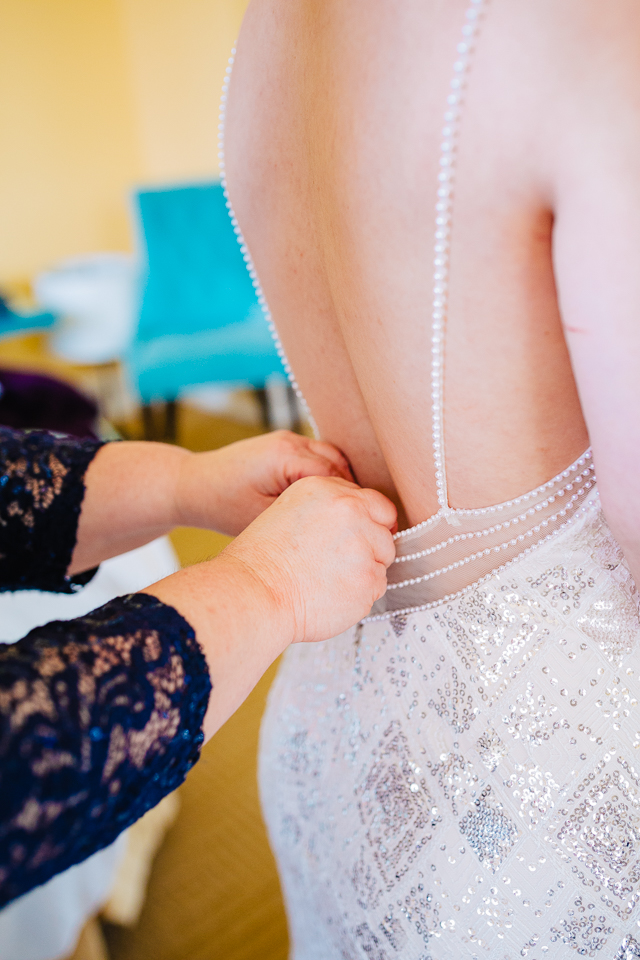 Mom buttoning up bride's dress for a Portland wedding.