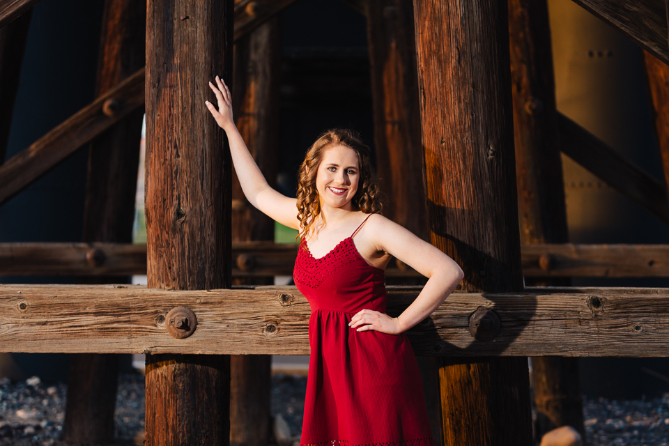 Senior girl posing by railroad bridge. 