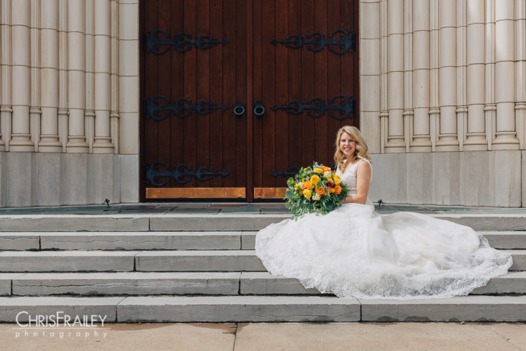 Bride sitting on stone steps posing in front of a church in Fort Worth Texas.