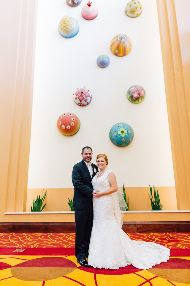 Bride and groom posing in front of a large mural at the Renaissance Hotel in Glendale Arizona.