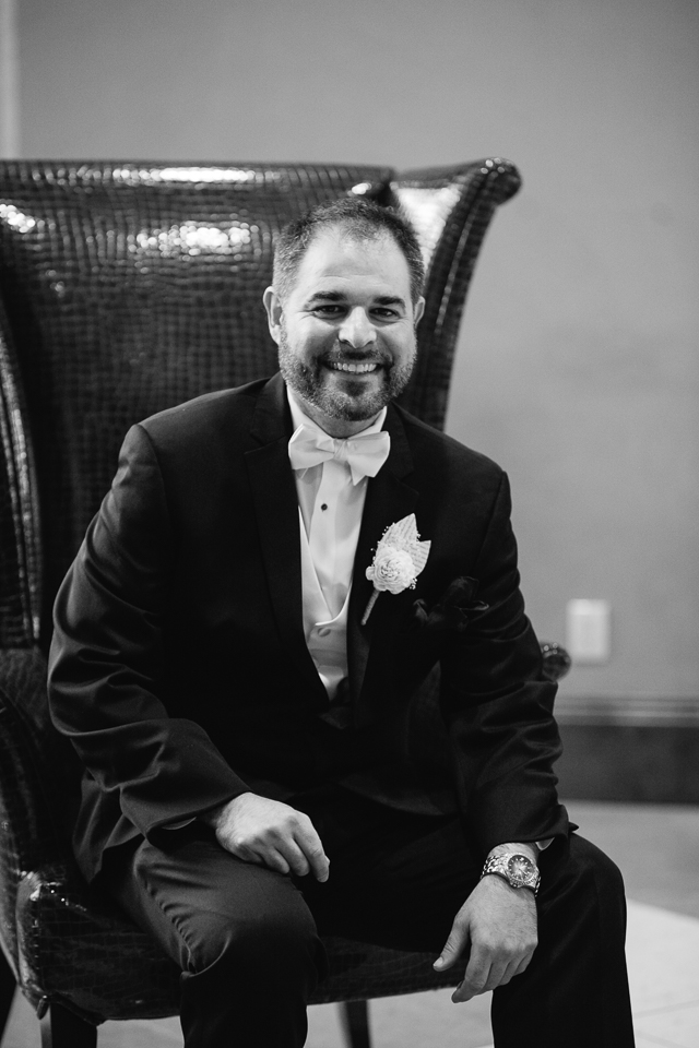 Groom posing in a leather chair at the Renaissance Hotel in Glendale Arizona.