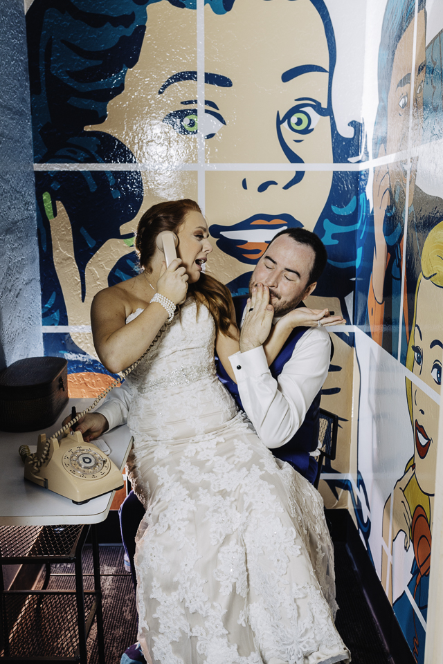 Bride and groom having fun in the phone room at their wedding at Because Event Space.
