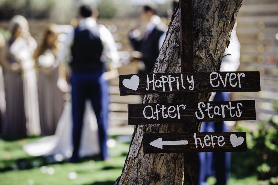 Sign saying "happily ever after starts here" at a wedding ceremony.