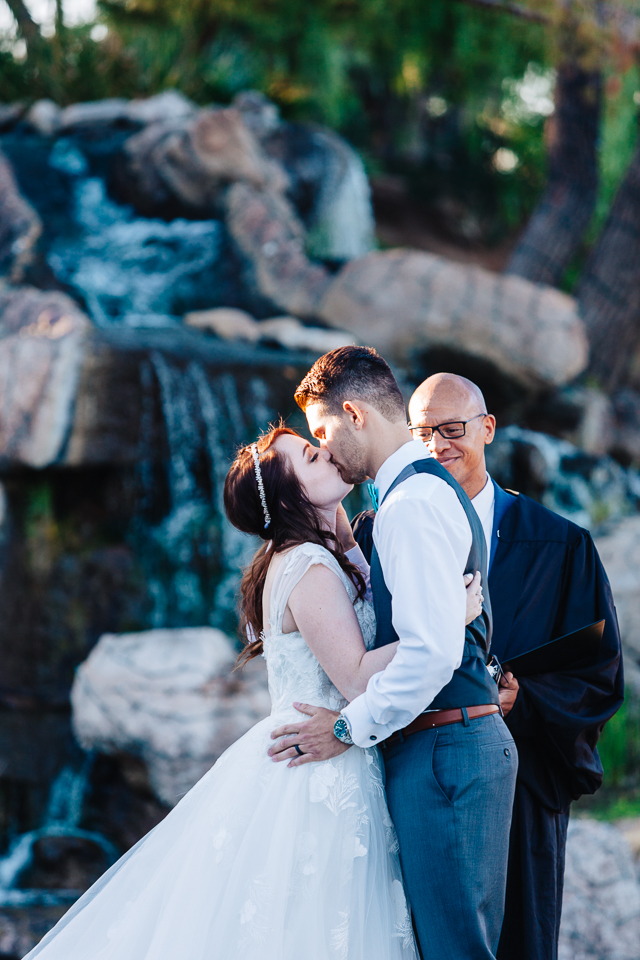 Bride and groom kissing at their wedding ceremony at Val Vista Lakes.