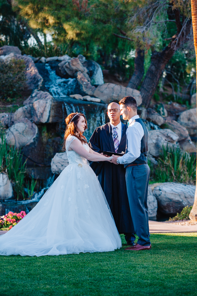 Bride and groom exchanging vows at fun filled Val Vista Lakes wedding.