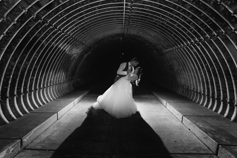 Groom dipping the bride in a dark tunnel under Val Vista Road.