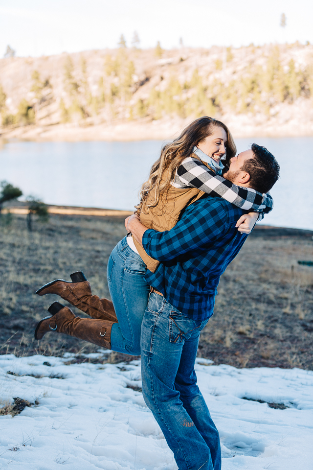 Engaged couple playing in the snow at Black Canyon Lake. 