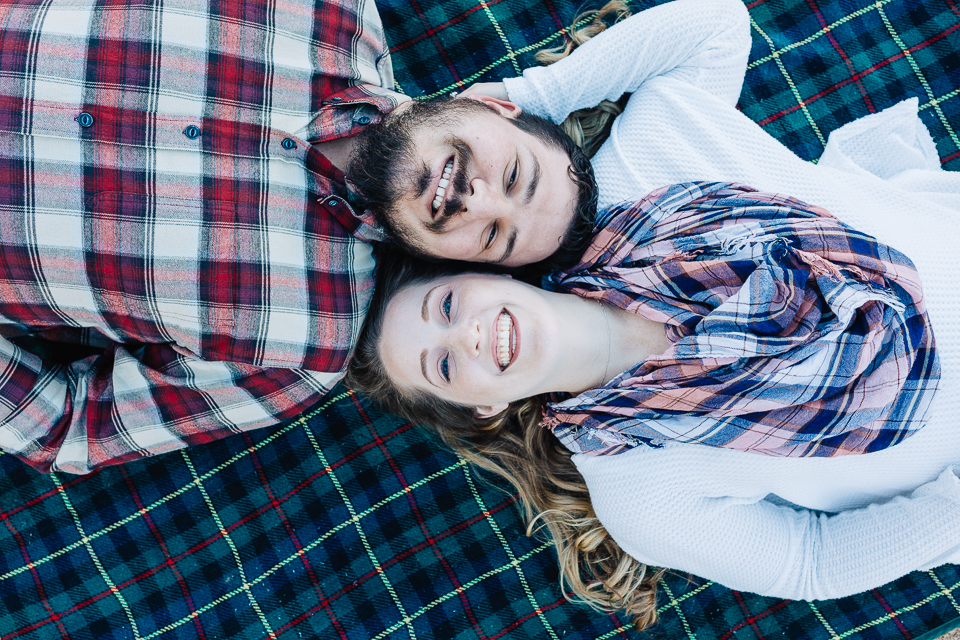 Couple laying on a blanket for their engagement session in Payson.
