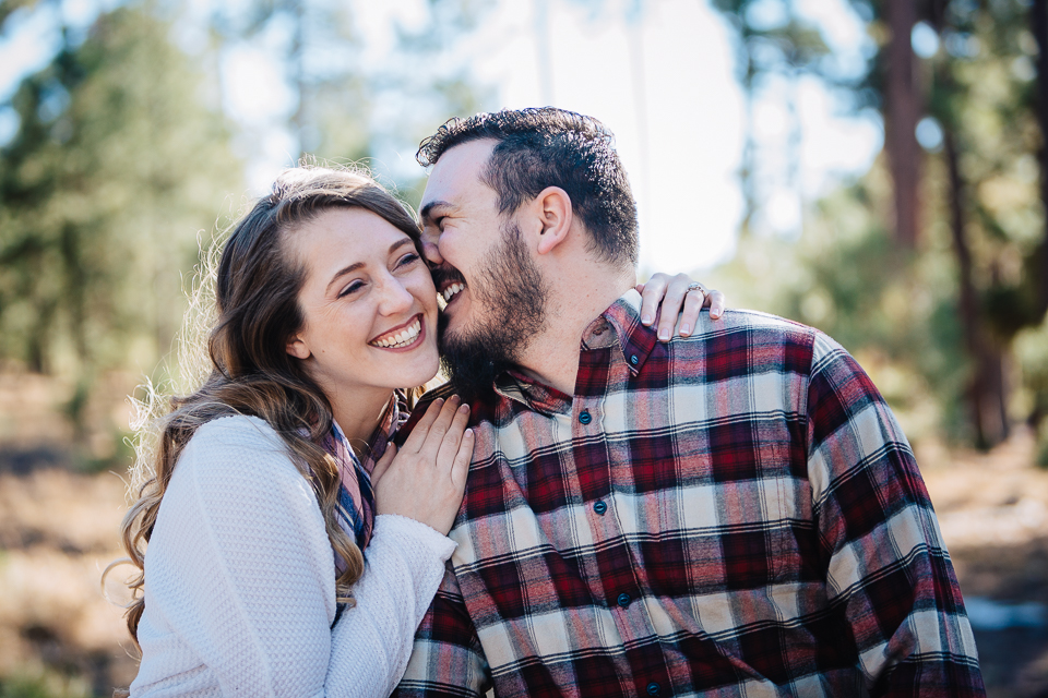 Couple whispering and laughing during their engagement session. 