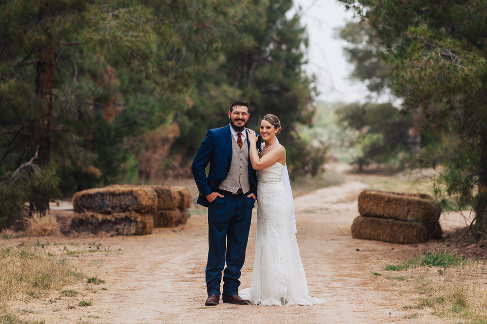 Bride and groom standing in middle of a dirt road as they get ready for their Schnepf Farms wedding. 