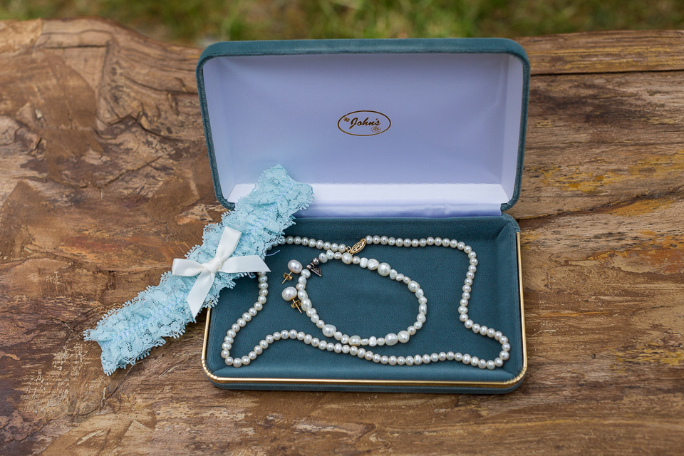 Bride's wedding details, garter, pearl necklace. 