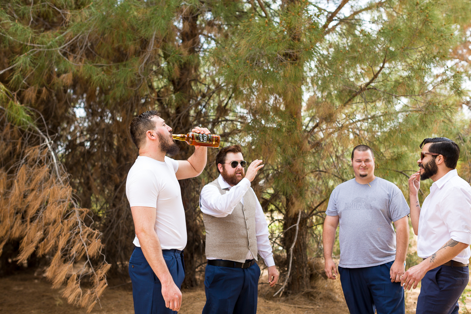 Groom and groomsmen drinking from a whiskey bottle. 