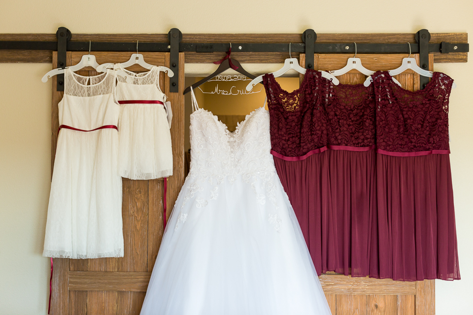 Bride's wedding dress hanging with bridesmaid's dresses. 