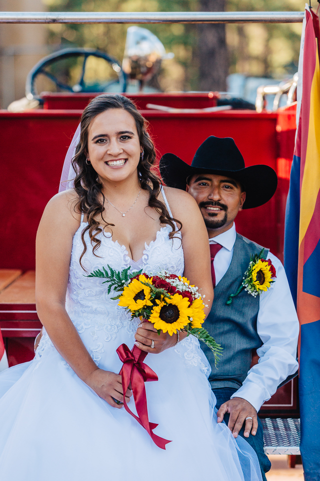 Bride and groom sitting in back of an old American LaFrance firetruck.