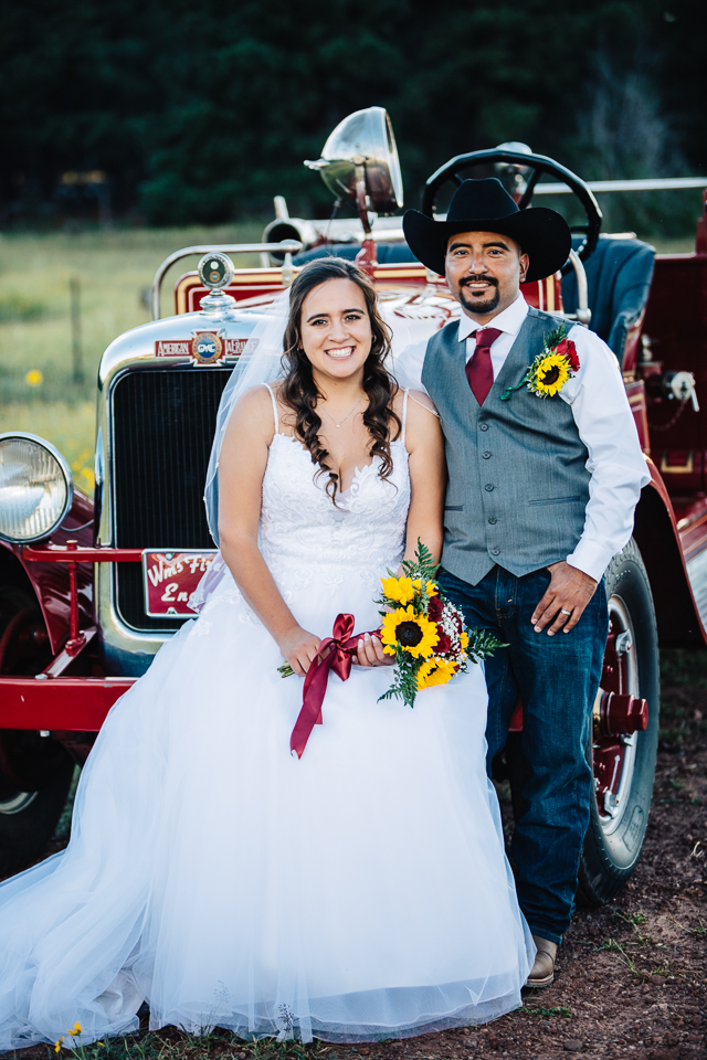 Bride and groom posing in front of an American LaFrance firetruck in Williams Arizona. 