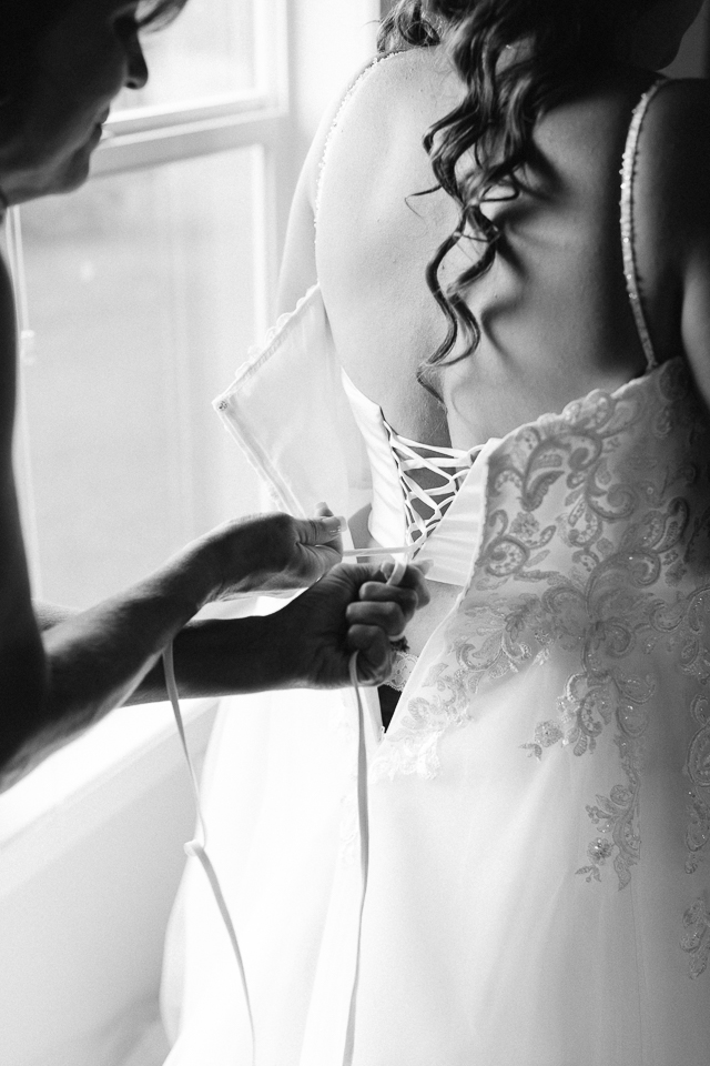 Mother of bride tying her wedding dress up. 