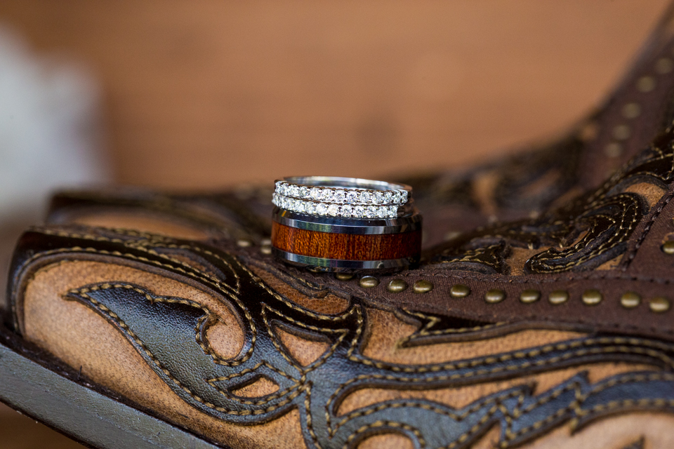 Wedding rings laying on top of cowboy boots. 