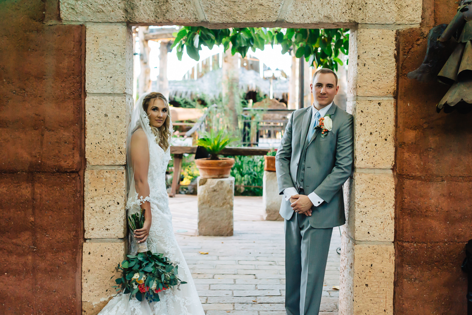 Bride and groom standing in stone entryway at Boojum Tree wedding. 