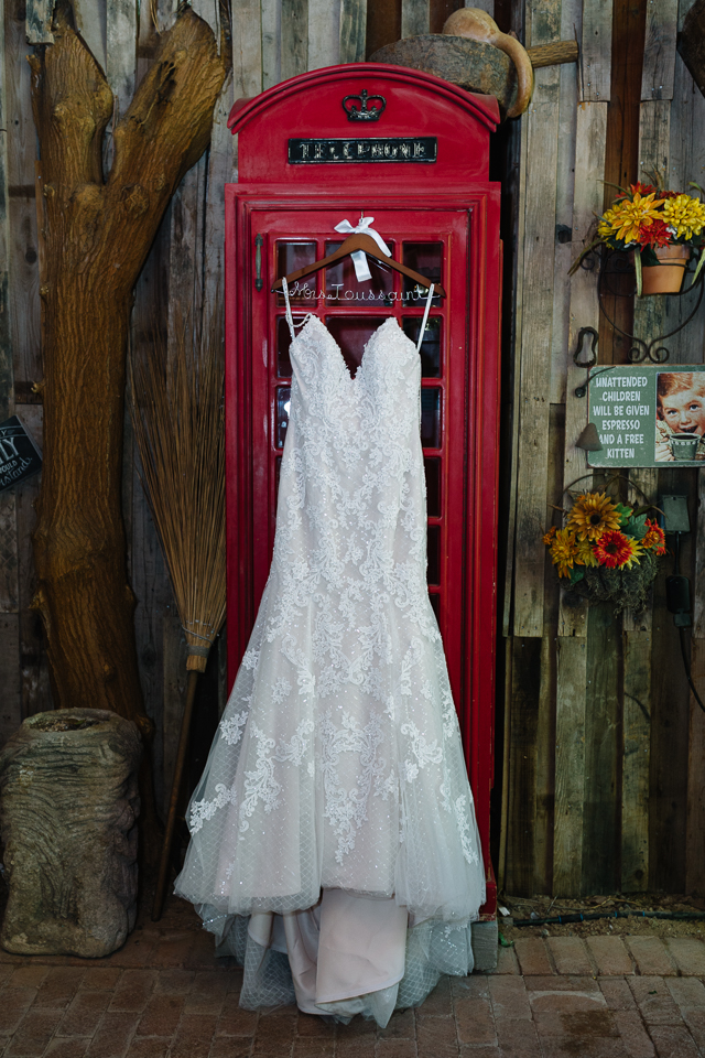 Bride's wedding dress hanging in front of red telephone booth Boojum Tree wedding. 