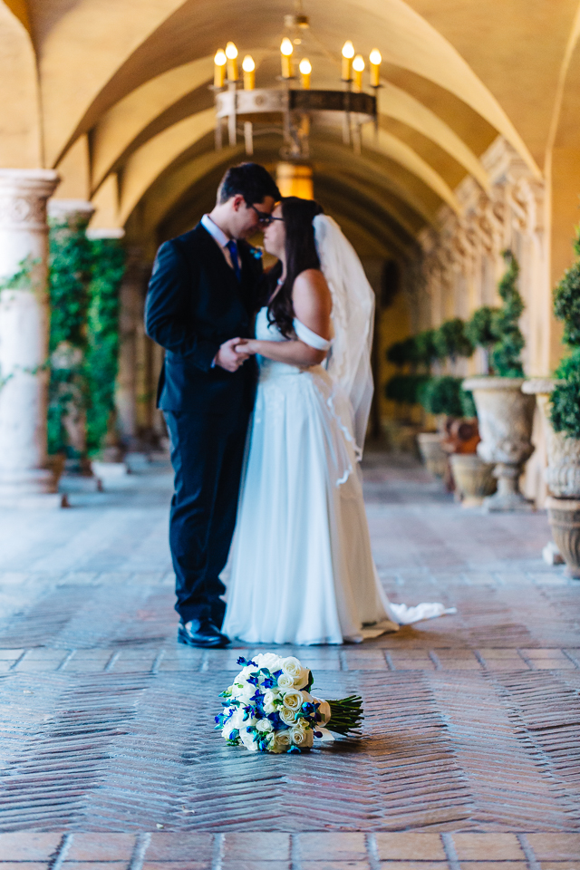Bride and groom embracing in courtyard of Villa Siena. 