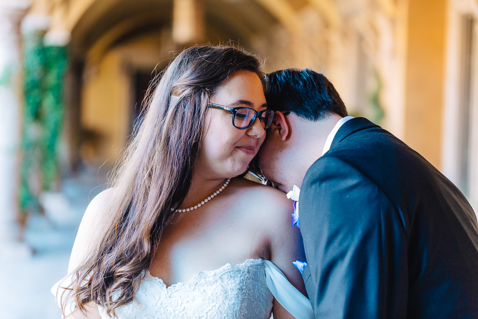 Groom kissing the neck of the bride at Tuscany Wedding at Villa Siena.