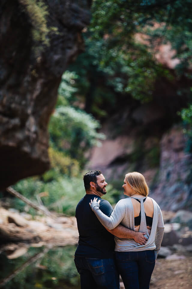 Engaged couple embracing at West Fork Trail.