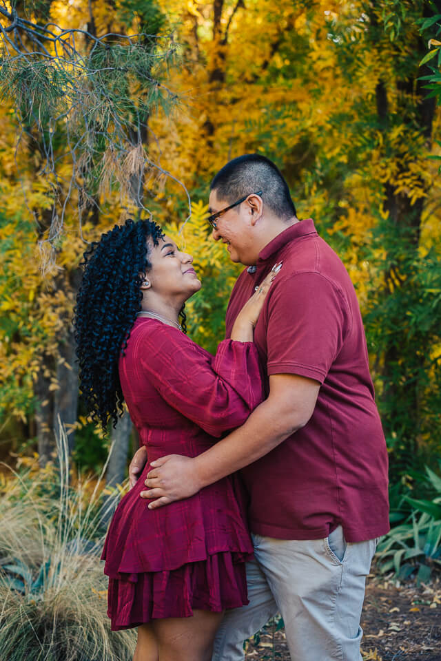 A young couple embrace during their engagement session at Boyce Thompson Arboretum.