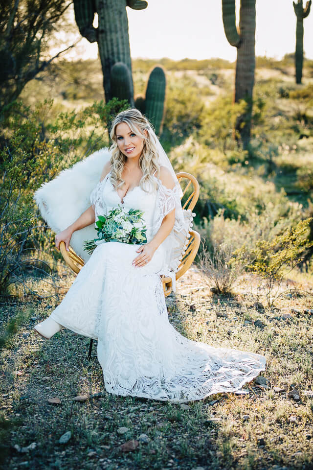 Bride posing in a wicker chair for her Arizona elopement style wedding in the desert.