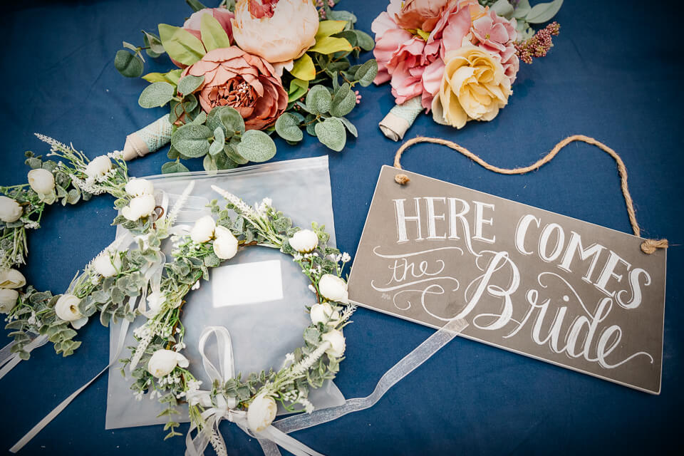 Flat lay wedding details of flowers and signage.