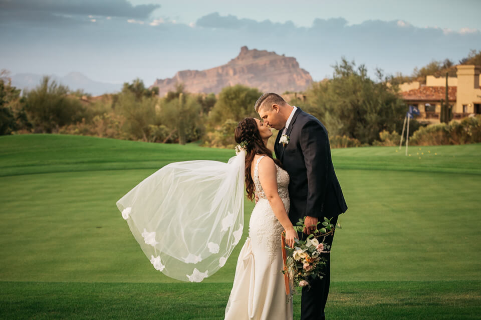Bride and groom kissing on a golf course
