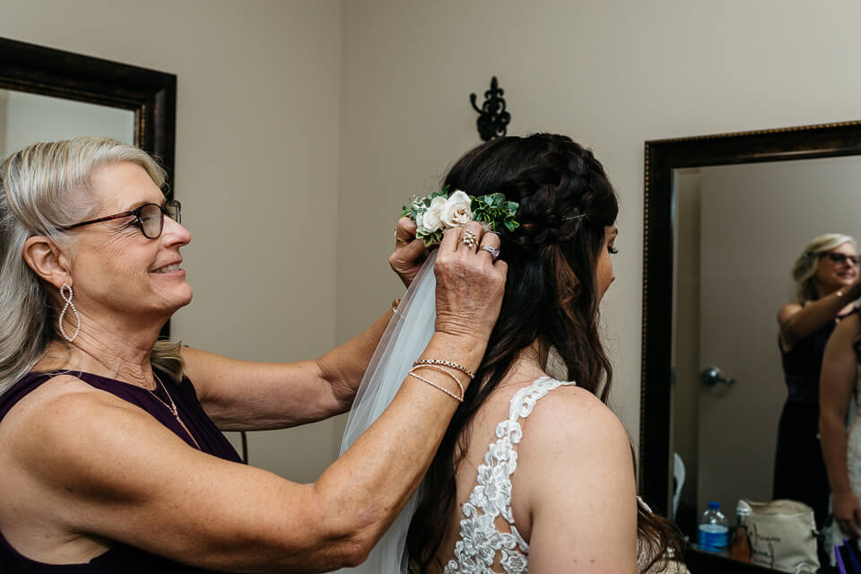 Mother helping bride with her veil.