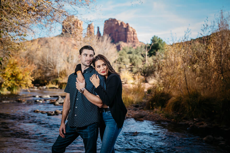 Couple holding each other at Oak Creek for their Sedona engagement photos.