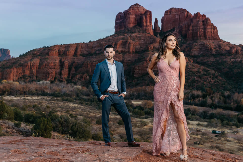 Engaged couple posing in evening wear in front of Cathedral Rock Sedona Arizona. 
