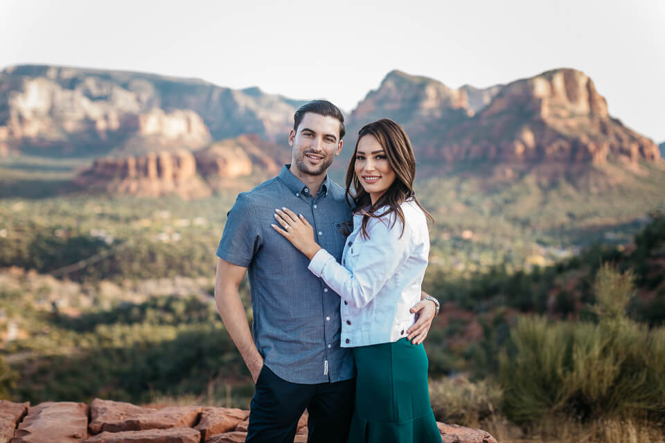 Engaged couple posing on top of Airport Mesa in Sedona Arizona. 