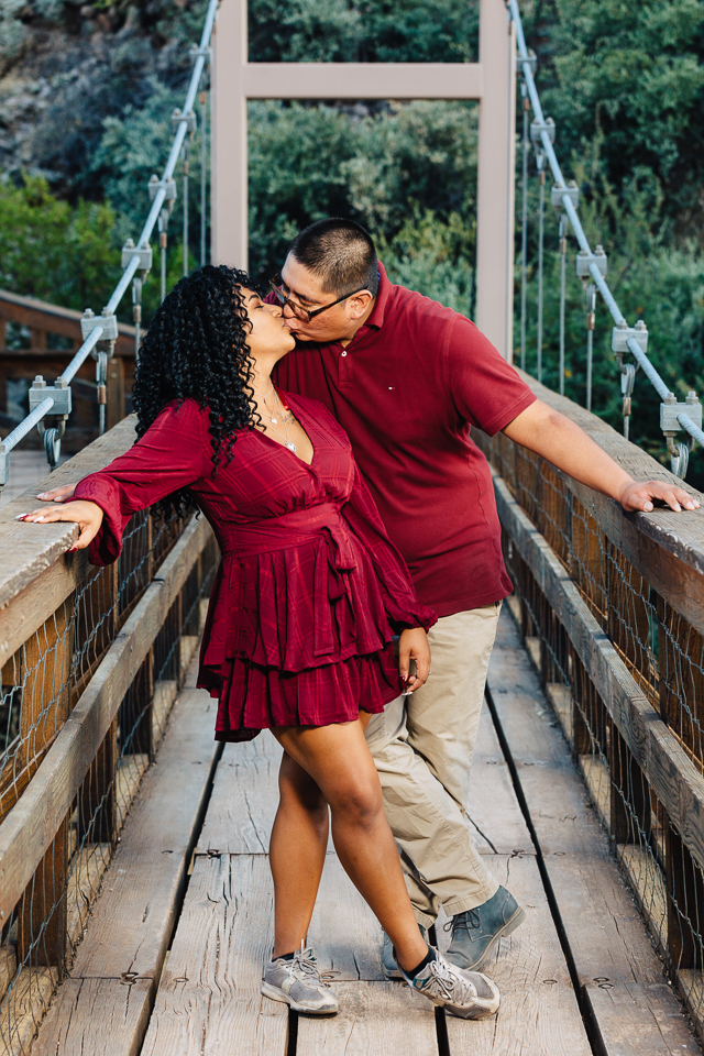Couple kissing on a wooden bridge at Boyce Thompson Arboretum.