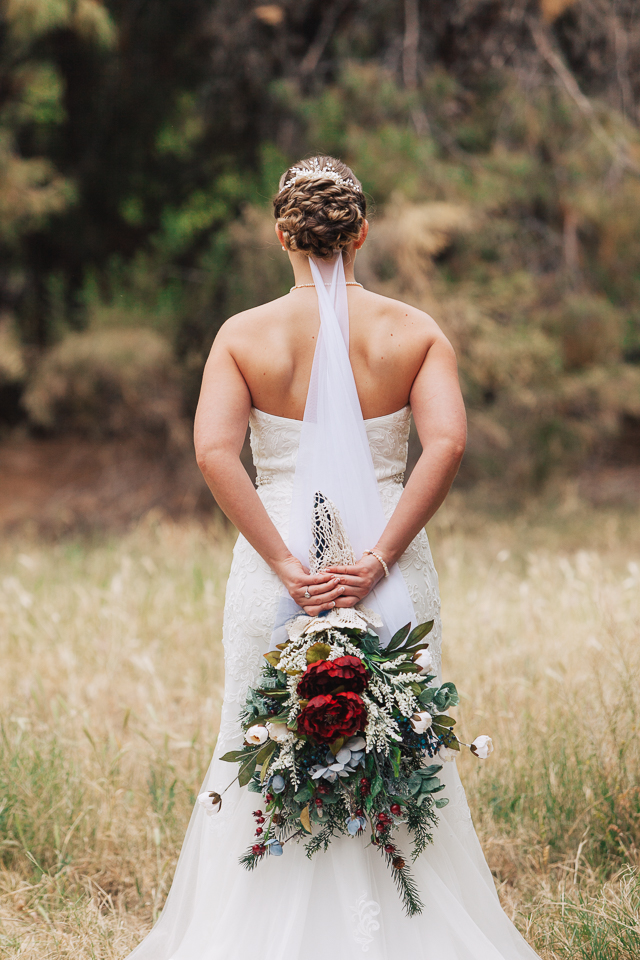 Bride holding her bouquet behind her back.