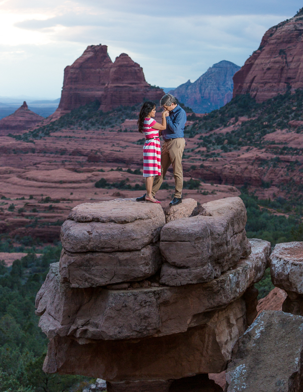Couple standing on small mesa of rock in Sedona Arizona.